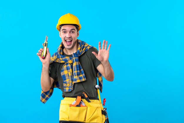 front view male builder in helmet with different tools on blue background building job flat constructor builder house worker