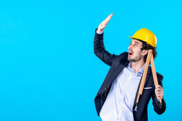 front view male builder holding wooden device on blue background business constructor job architecture building work