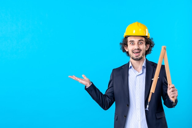 front view male builder holding wooden device on blue background business design constructor job architecture building work