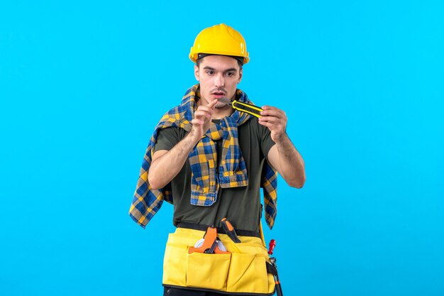 Фото Вид спереди мужчина строитель в шлеме на синем фоне строитель плоская архитектура конструктор дом работа строительный рабочий