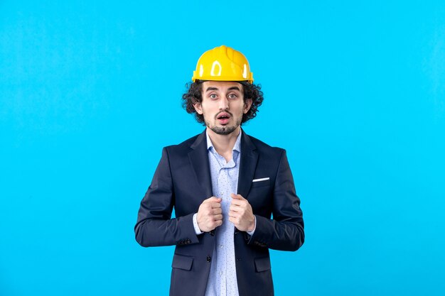 front view male builder in yellow helmet and suit on a blue background architecture work job business design constructor building