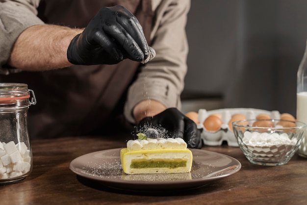 Photo front view male chef plating dessert