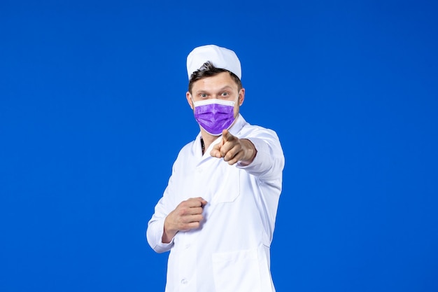 Front view of male doctor in medical suit and purple mask blue