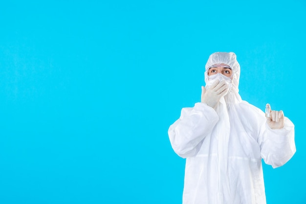 Front view male doctor in protective suit and mask on blue