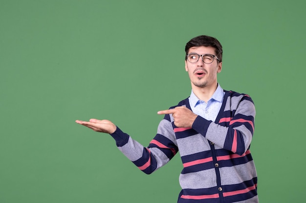 front view male teacher pointing aside on green background book student school woman color lesson work library university college