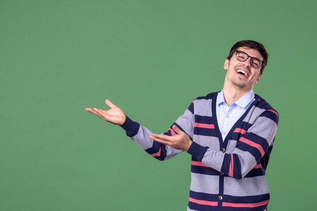 front view male teacher pointing aside and laughing on green background woman school student library university work color college lesson