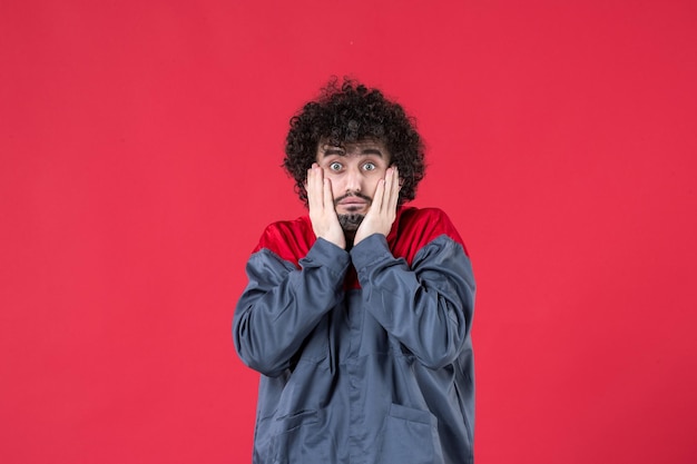 Front view male worker in uniform on red background uniform color tool mechanic worker instrument job house photo