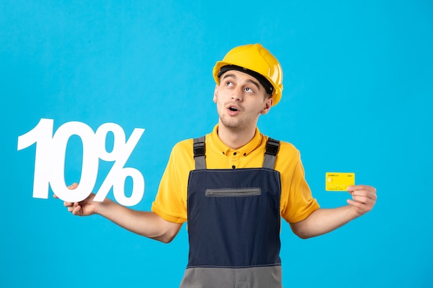 Front view male worker in uniform with writing and credit card on blue 