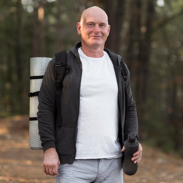 Photo front view man carrying yoga mat