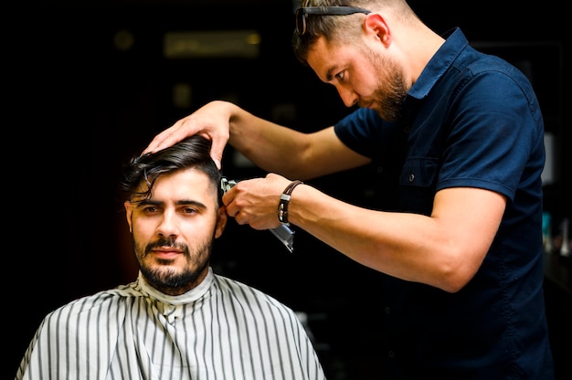 Vista frontale dell'uomo che ottiene un taglio di capelli