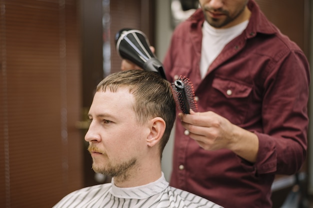 Photo front view of man having his hair dryed