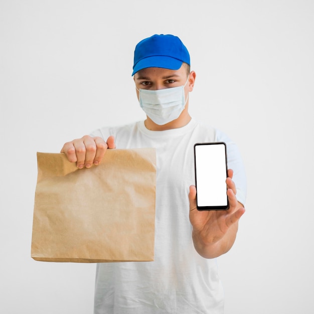 Photo front view man holding bag and phone