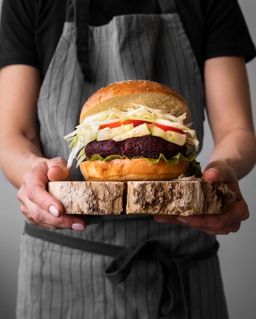 Photo front view man holding a hamburger