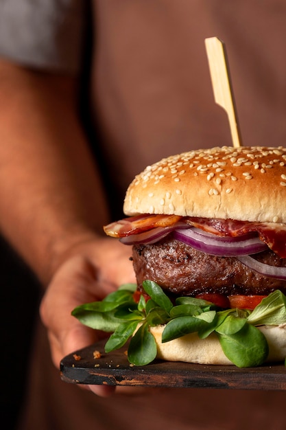 Photo front view man holding tray with burger