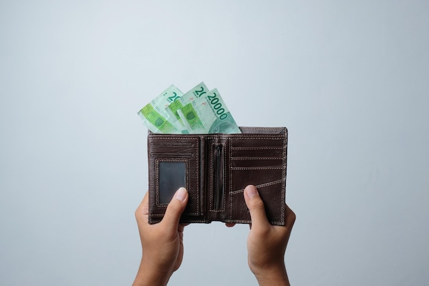 Photo front view of man holding wallet with indonesian money
