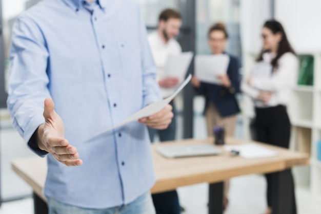 Foto vista frontale dell'uomo nell'ufficio che offre una stretta di mano