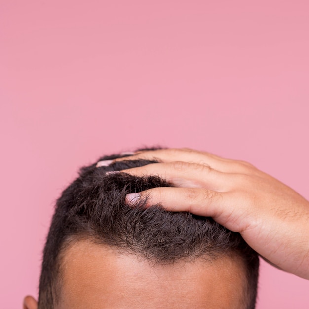 Front view of man running his fingers through his hair with copy space