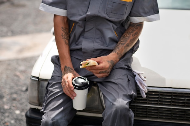 Photo front view man sitting on car