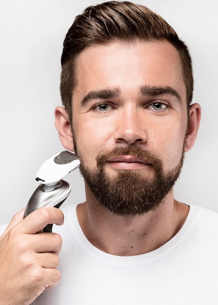 Photo front view man using a shaving machine