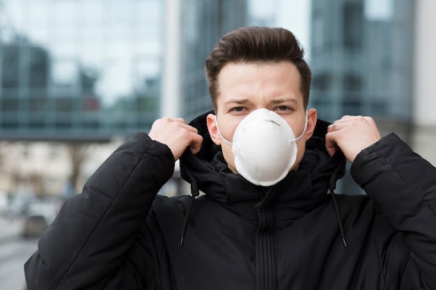 Front view of man wearing a medical mask outside