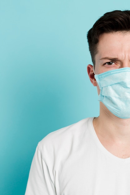 Foto vista frontale dell'uomo che indossa una maschera medica e una posa