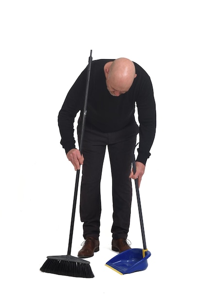 Front view of a man with a broom and dustpan sweeping on white background