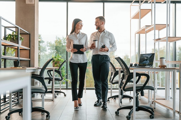 Foto vista frontale l'uomo e la donna lavorano insieme nell'ufficio moderno