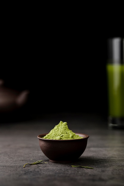 Photo front view of matcha tea powder in bowl with copy space