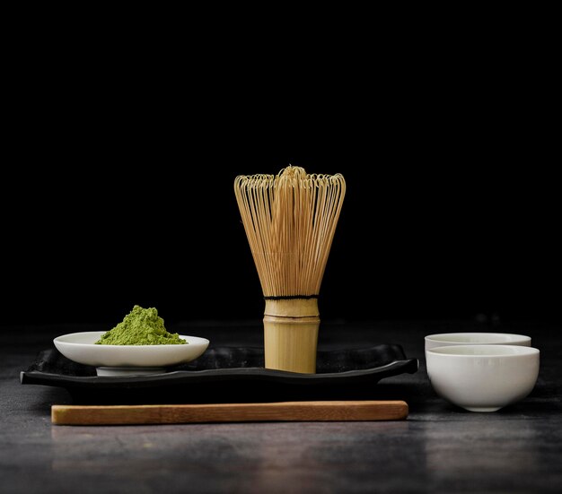 Photo front view matcha tea with bamboo whisk