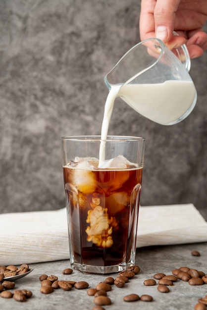 Front view milk poured in iced coffee