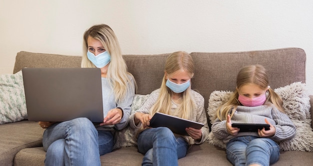 Front view of mom and daughters with technology