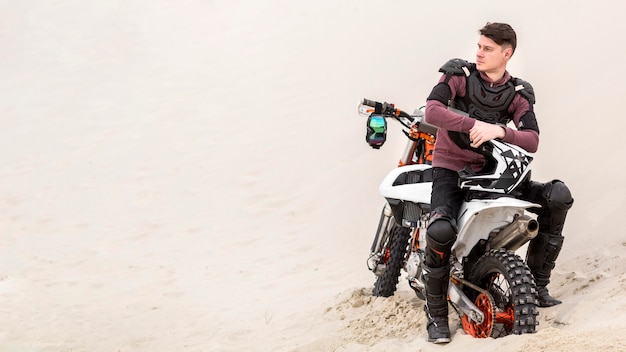 写真 砂漠でリラックスした正面バイクライダー