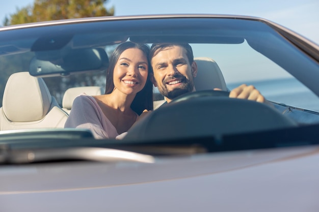 Front view of multiethnic couple driving in the auto