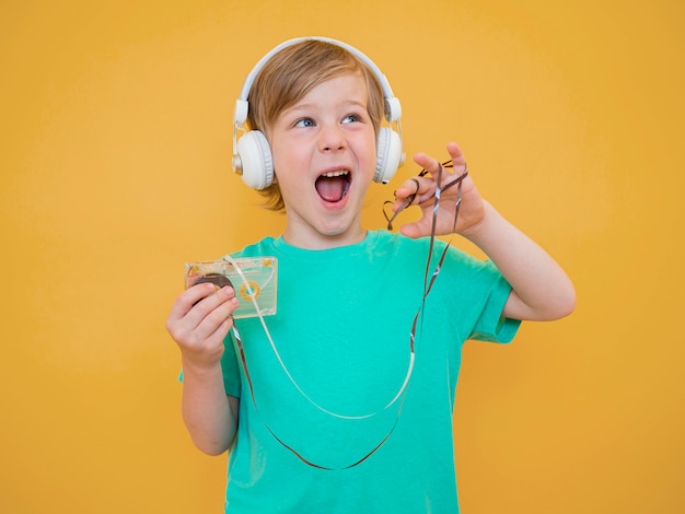 写真 音楽を聴くかわいい男の子の正面図