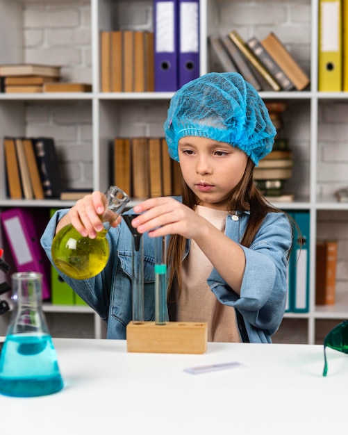Вид спереди девушки с сеткой для волос, проводящей научные эксперименты