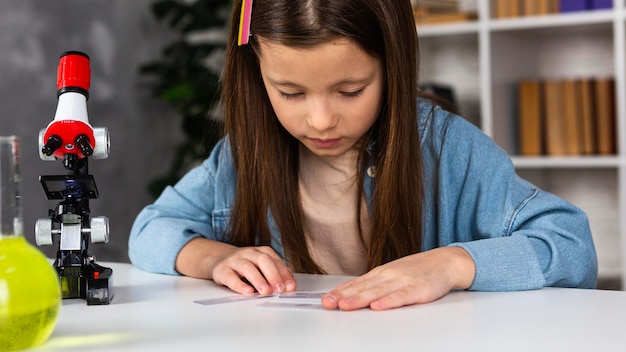 写真 顕微鏡と試験管を持つ少女の正面図