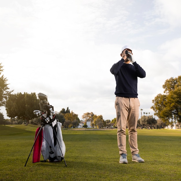 Фото Вид спереди человека с биноклем на поле для гольфа