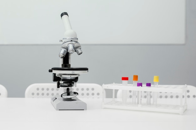 試験管を備えた実験室のテーブル上の顕微鏡の正面図