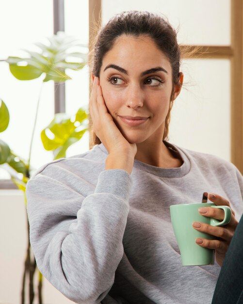 Фото Вид спереди смайлика женщины с кофе дома