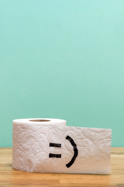 Фото Вид спереди рулона туалетной бумаги с копией пространства и смайлик