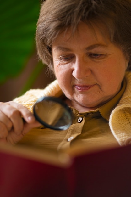 Front view old woman reading at home