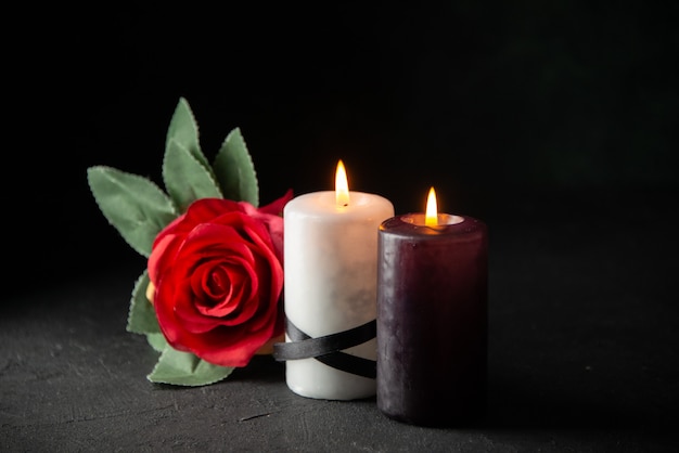 Front view of pair of candles on black