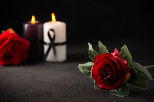Front view of pair of candles with red flowers on black