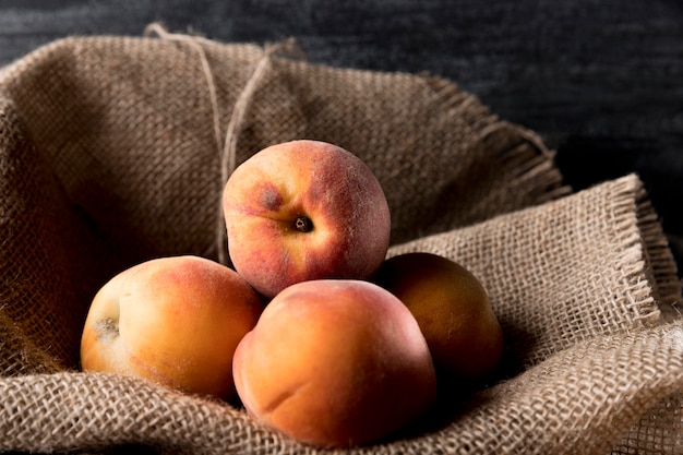 Photo front view of peaches on burlap