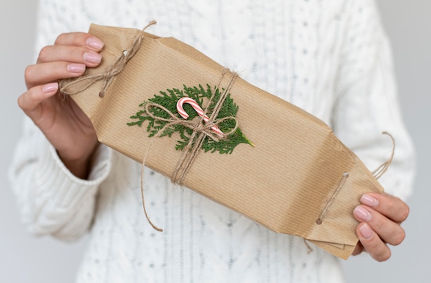 Photo front view of person holding decorated christmas gift with candy cane