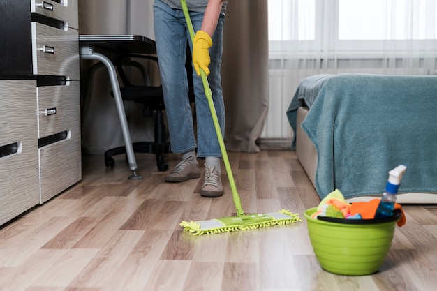 Photo front view of person mopping floor in the room