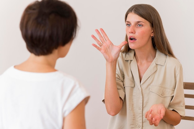 Front view of person teaching woman the sign language