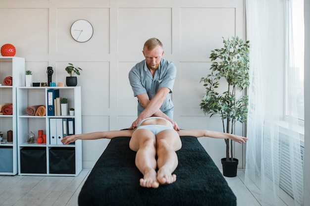 Front view of physiotherapist performing exercises on female patient