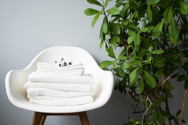 Photo front view pile of towels on a chair