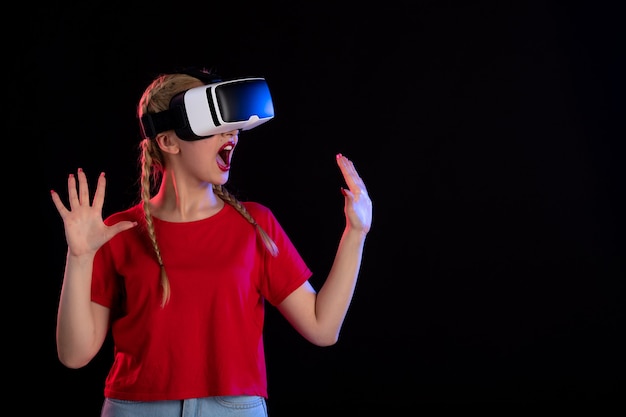 Front view of pretty female excitedly playing vr on dark  fantasy games